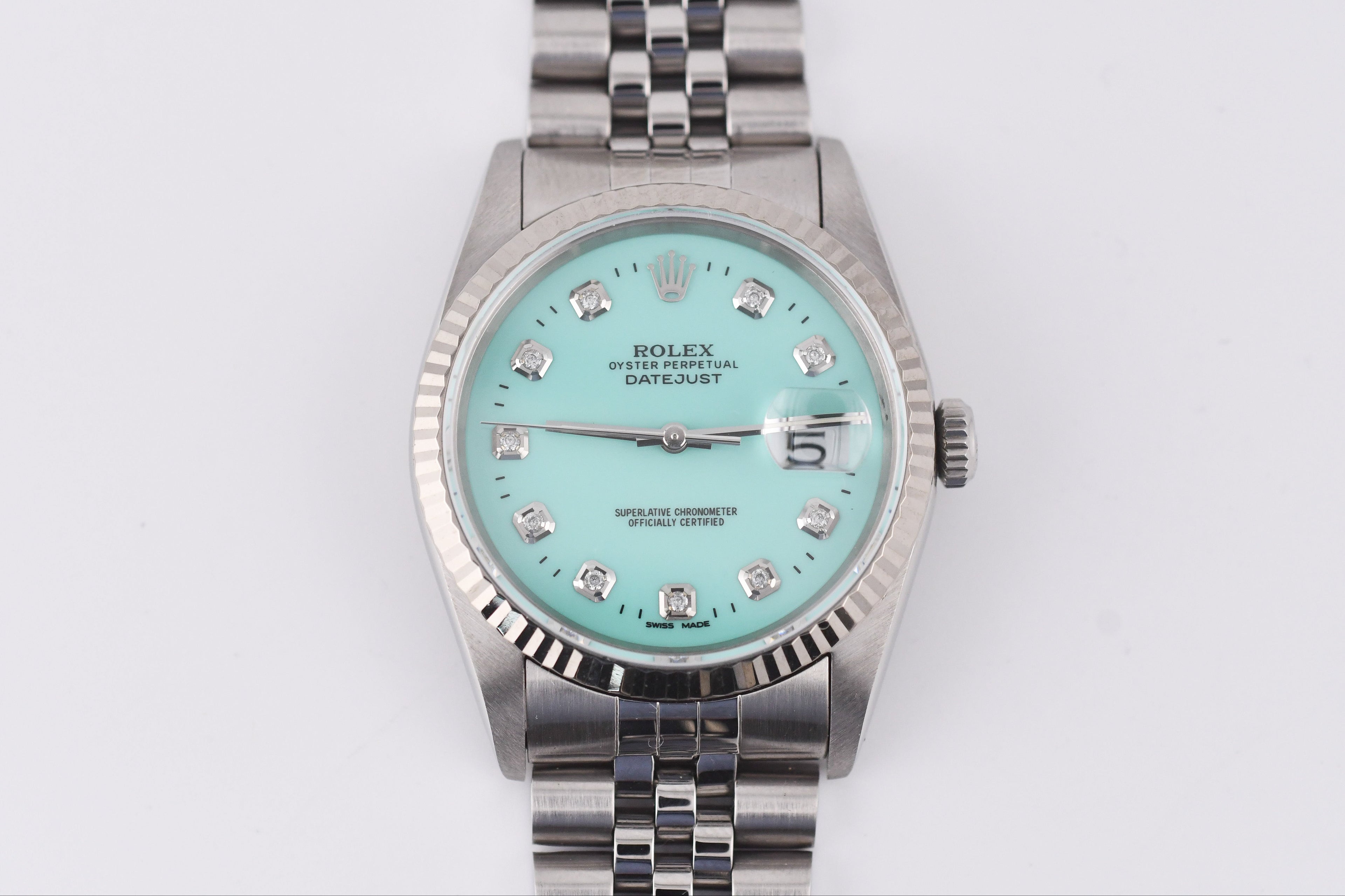 Silver watch with a turquoise dial on a white background