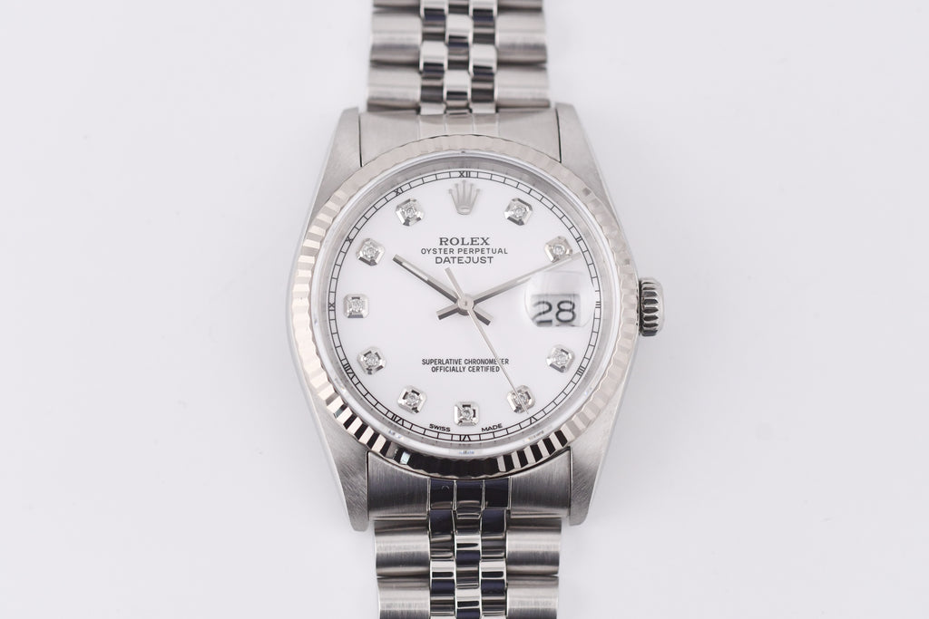 Silver watch with a white face on a light gray background