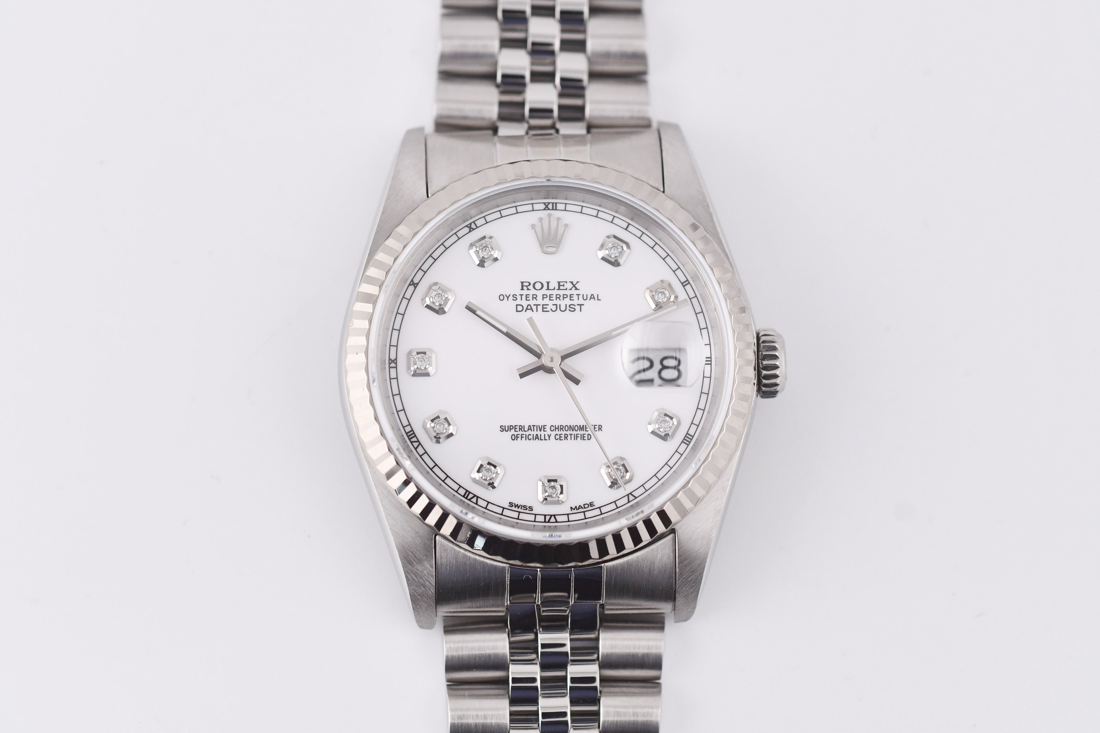 Silver watch with a white face on a light gray background
