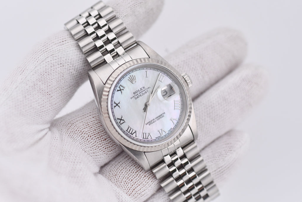 Silver watch with a white face on a light gray background