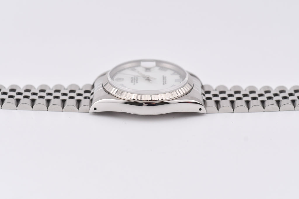 Silver watch with a white face on a light gray background