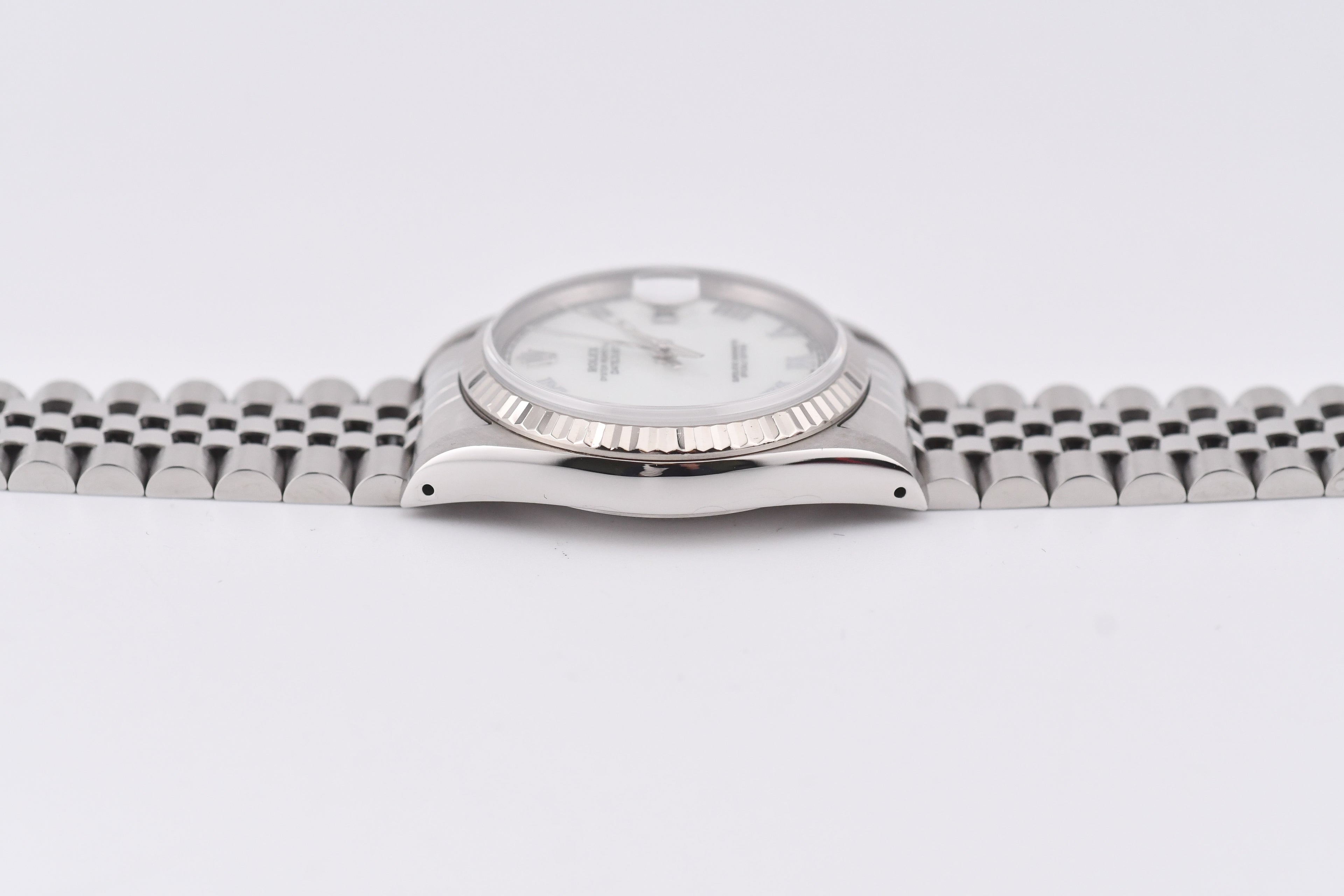Silver watch with a white face on a light gray background