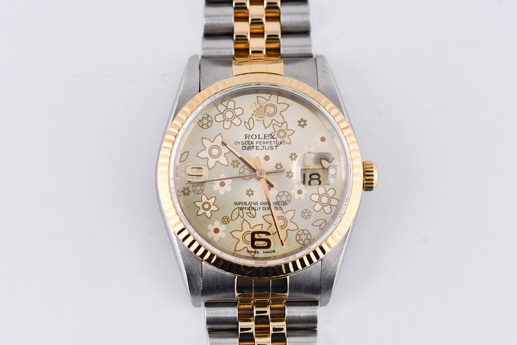 Two-tone watch with floral patterned face on a light gray background