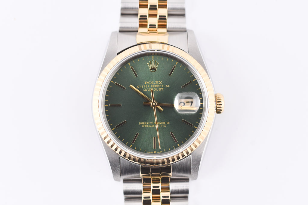 Rolex watch with green dial and gold and silver band on white background