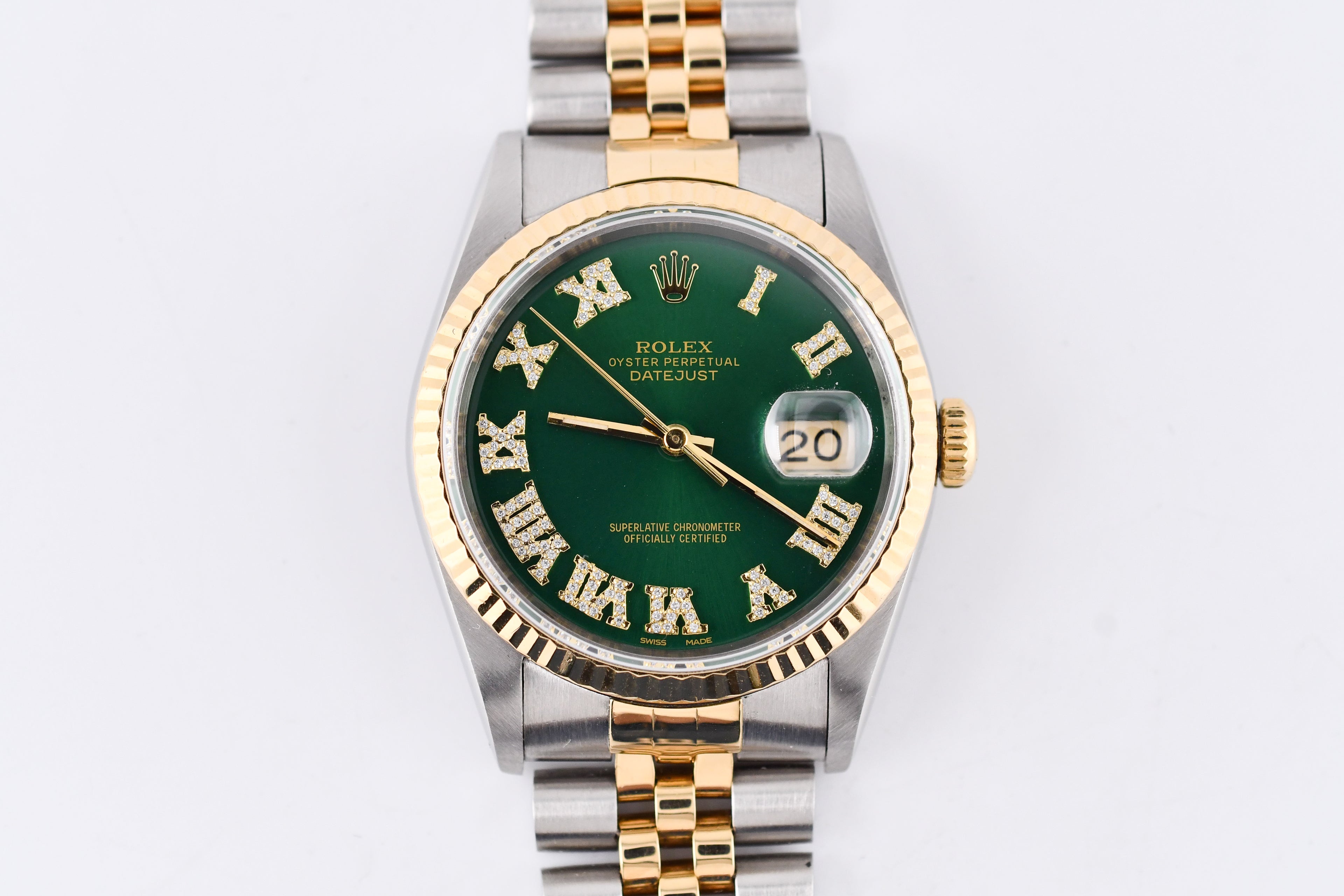 Rolex watch with green dial and gold and silver case on a white background