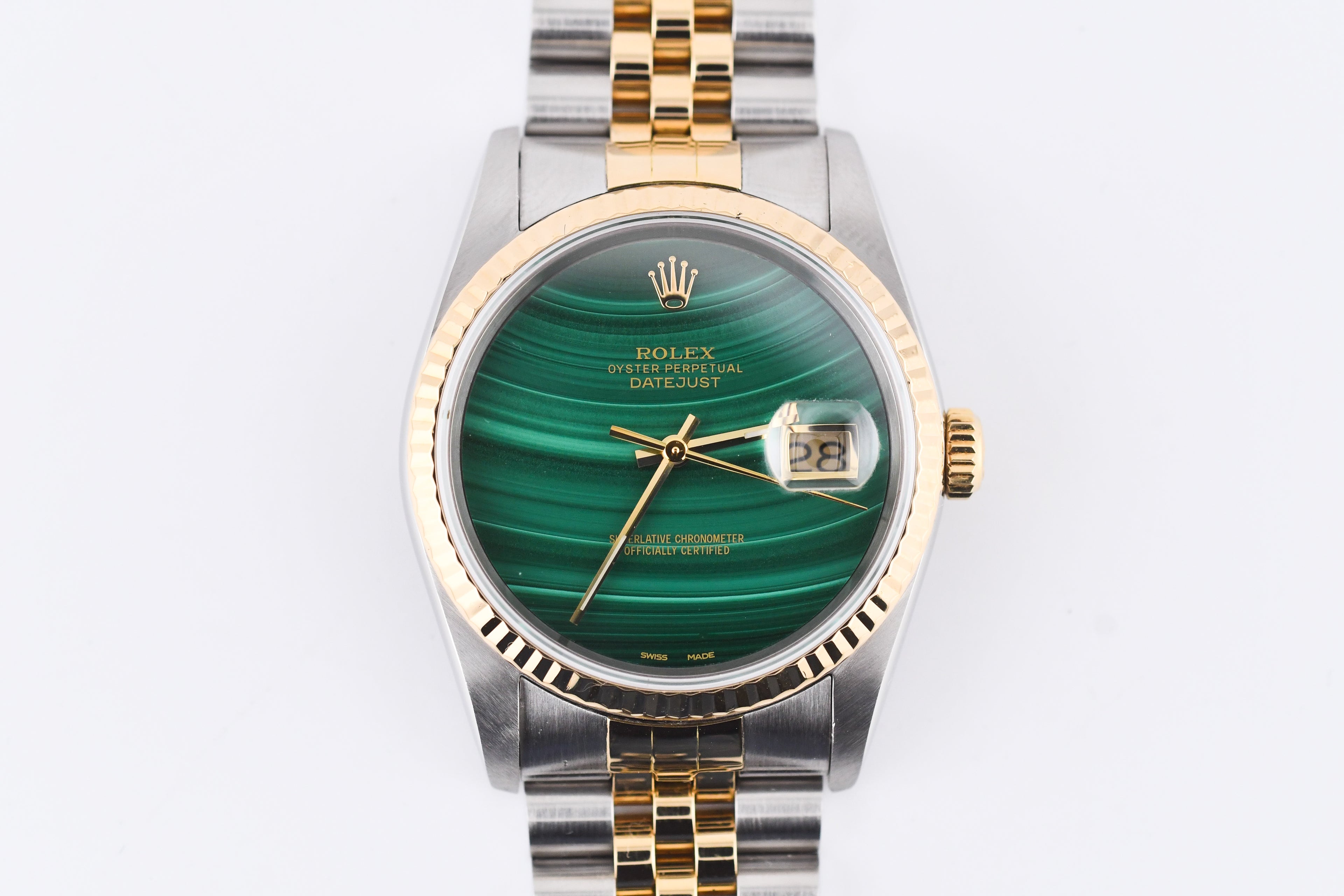 Rolex watch with green face and gold and silver band on white background
