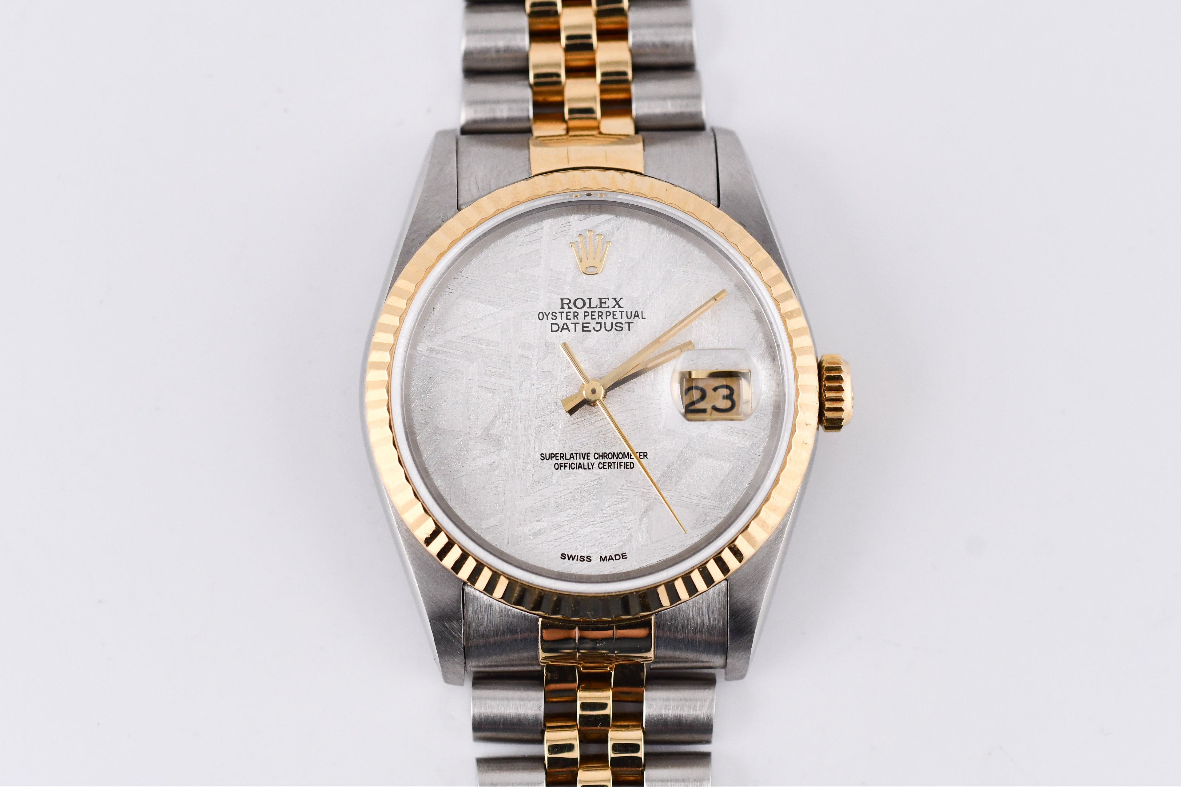 Rolex watch with two-tone metal band on a light gray background