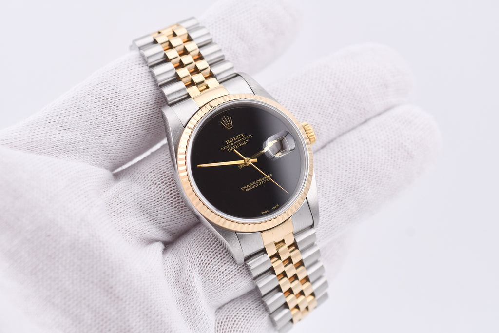 Luxury watch with gold and silver band on a white fabric background