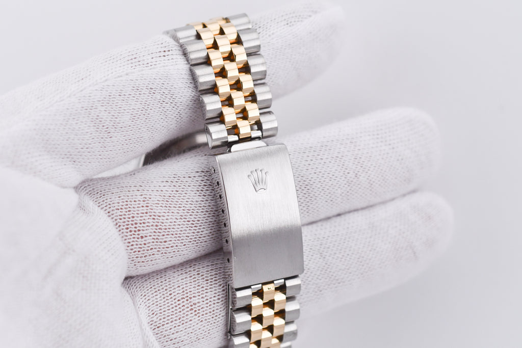 Silver and gold watch on a white fabric background