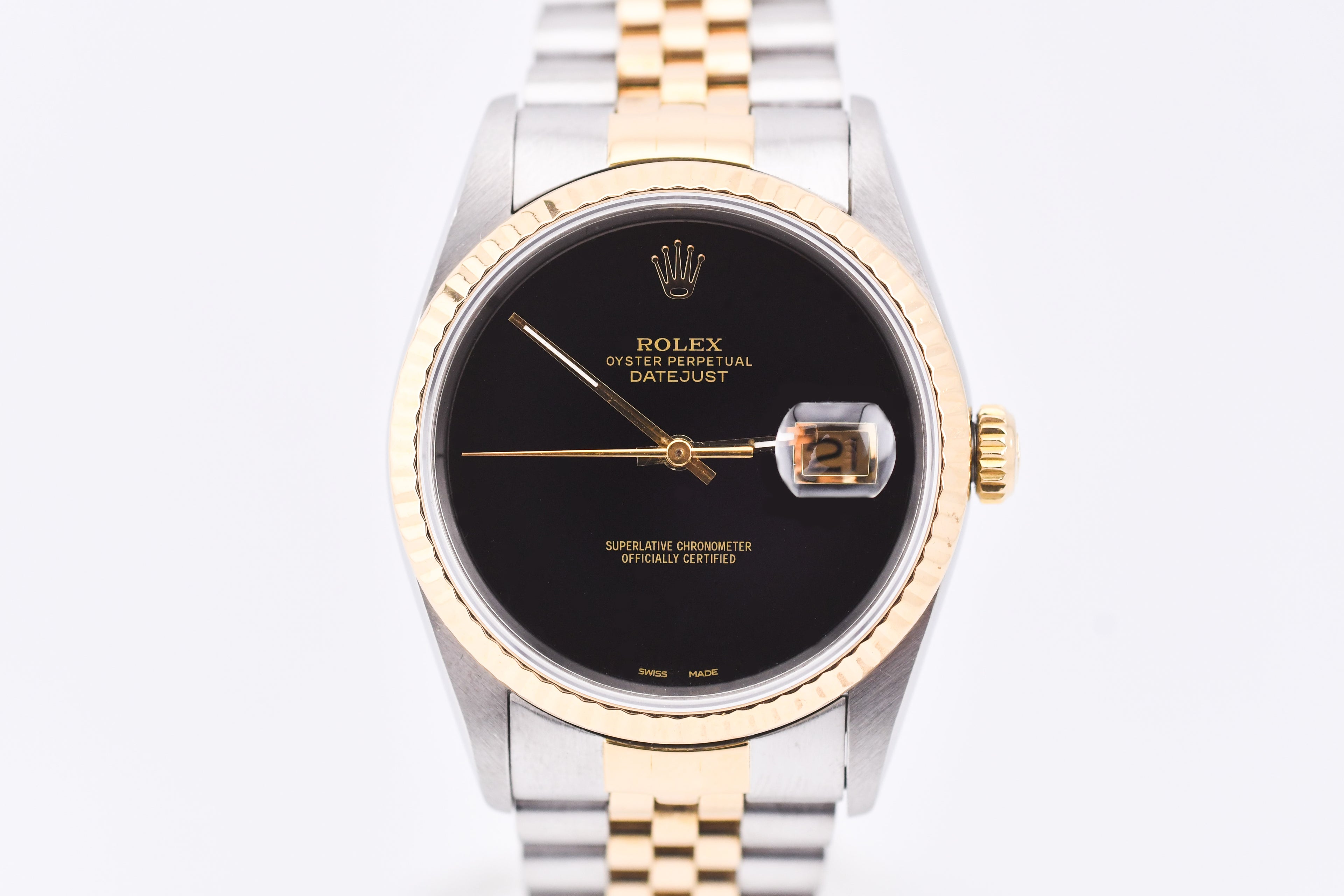 Rolex watch with black dial and gold and silver band on white background