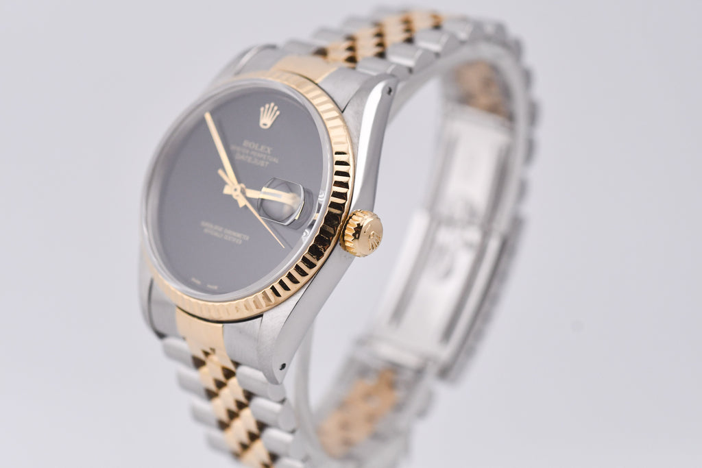 Two-tone watch with silver and gold band on a light gray background
