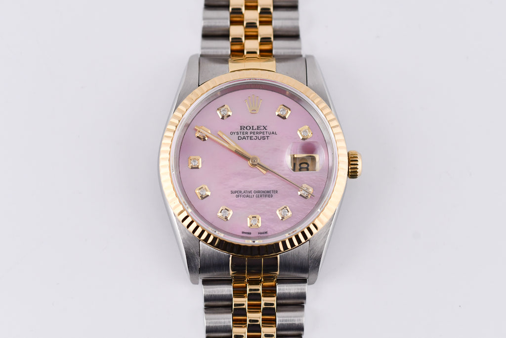 Rolex watch with pink dial and gold and silver band on a white background