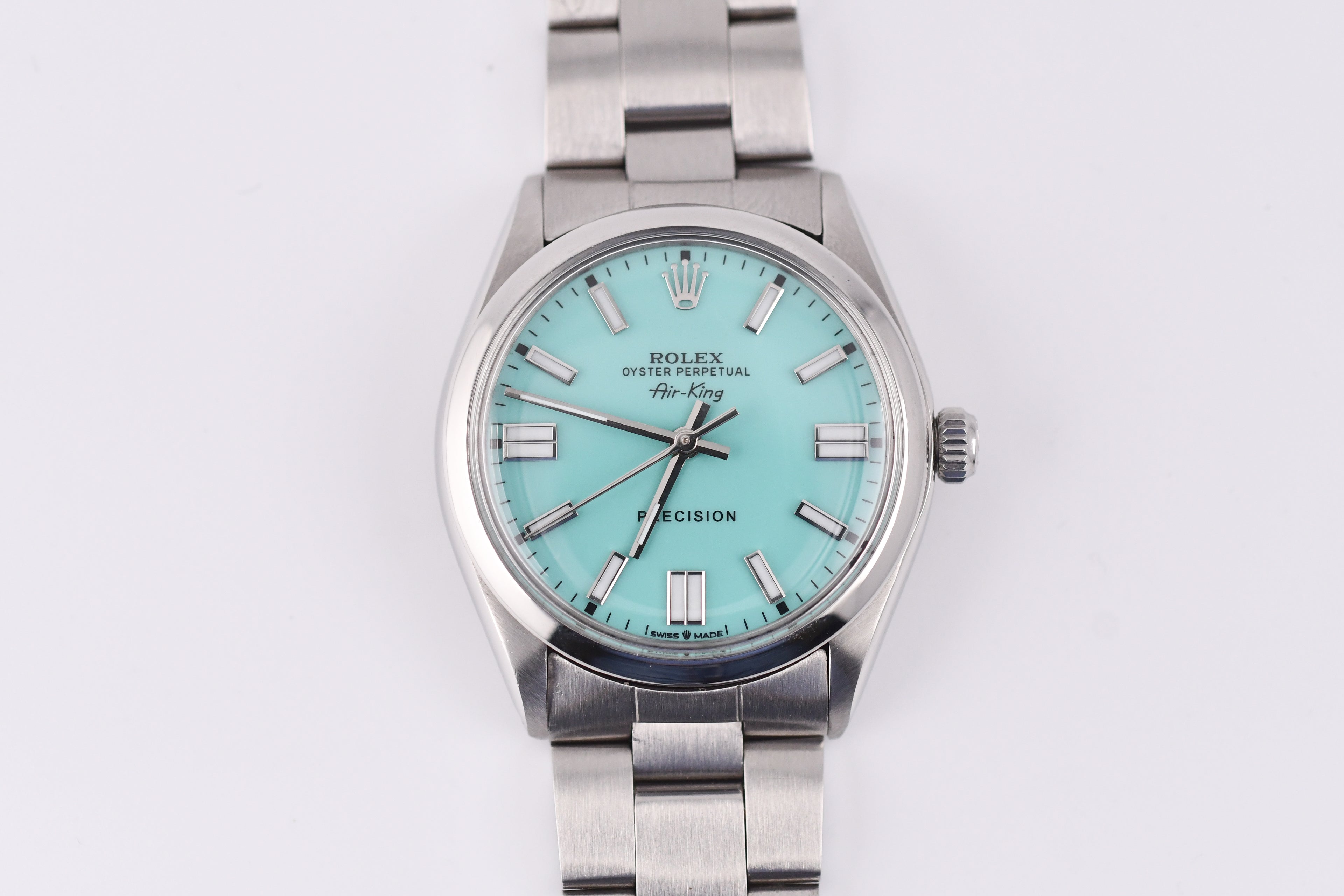 Silver Rolex watch with a turquoise dial on a white background