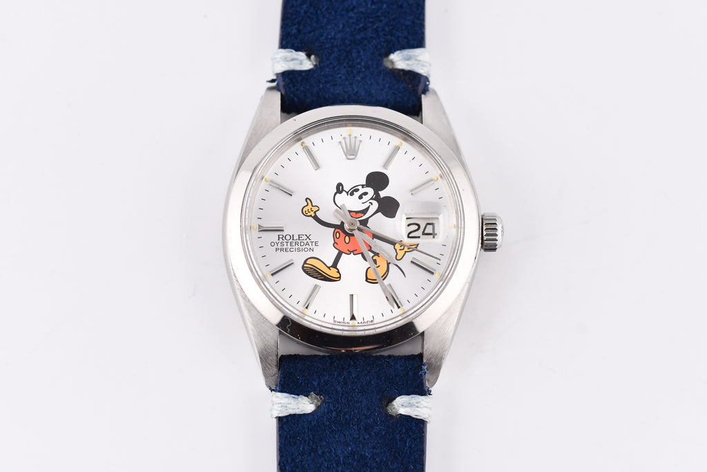 Wristwatch with a blue strap and Mickey Mouse face on the dial against a white background