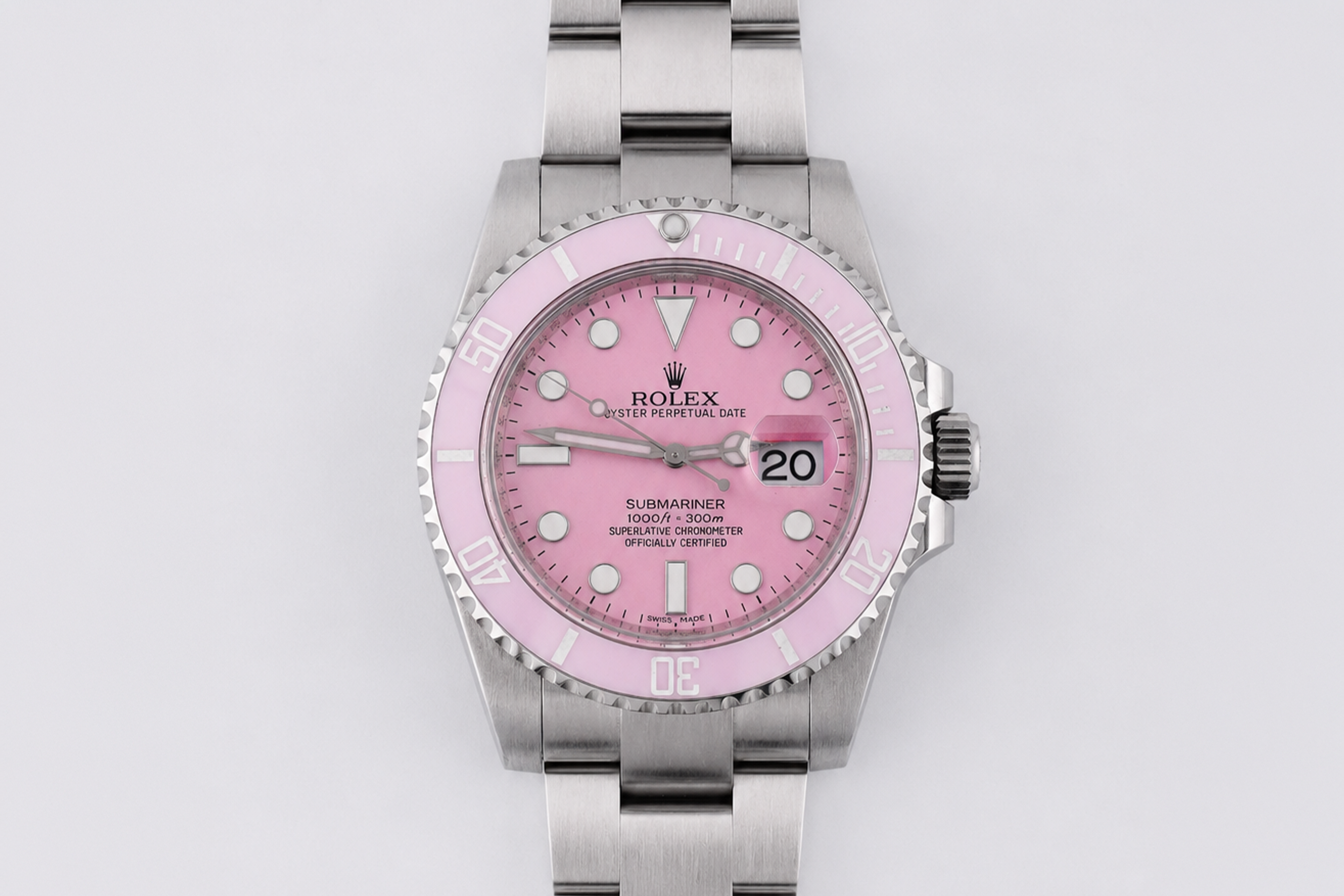Rolex watch with pink dial and silver case on a light gray background